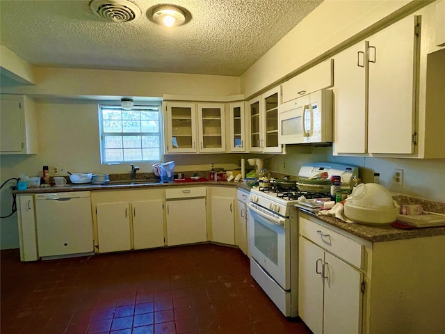 kitchen featuring white cabinets, a textured ceiling, white appliances, and sink