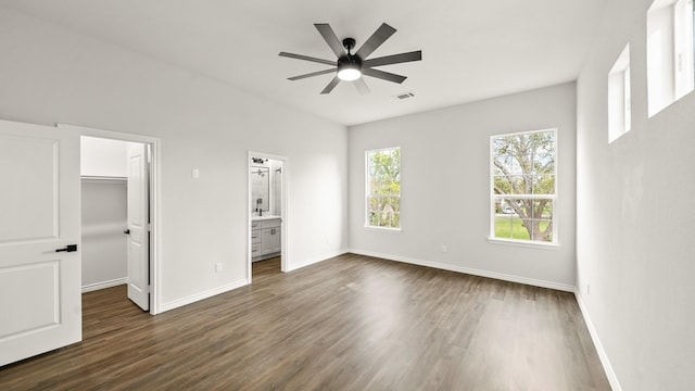 205 3rd St, Rosenberg, TX 77471 - unfurnished bedroom featuring dark wood-type flooring, a walk in closet, baseboards, and ensuite bathroom