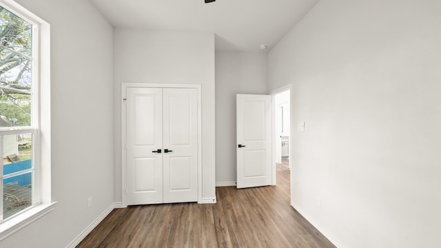 unfurnished bedroom featuring dark wood-type flooring and a closet