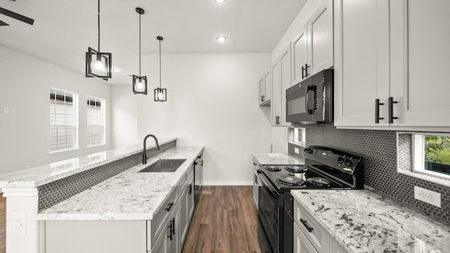 kitchen with dark hardwood / wood-style flooring, backsplash, sink, black appliances, and white cabinetry