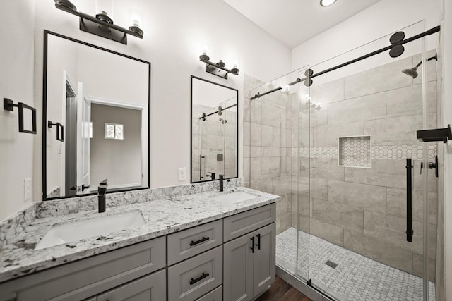 bathroom with a shower with door, vanity, and hardwood / wood-style flooring