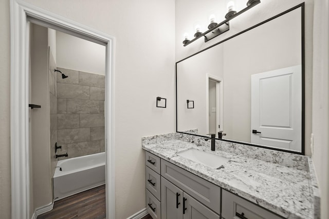 bathroom featuring tiled shower / bath combo, wood-type flooring, and vanity