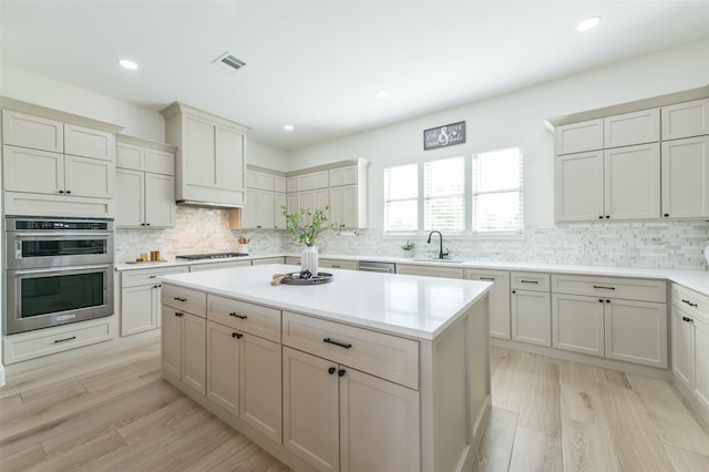 kitchen with a center island, sink, light wood-type flooring, and stainless steel appliances