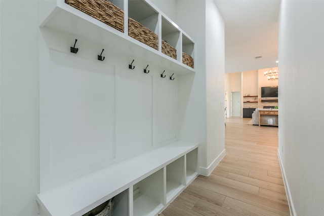 mudroom with a notable chandelier and light hardwood / wood-style floors