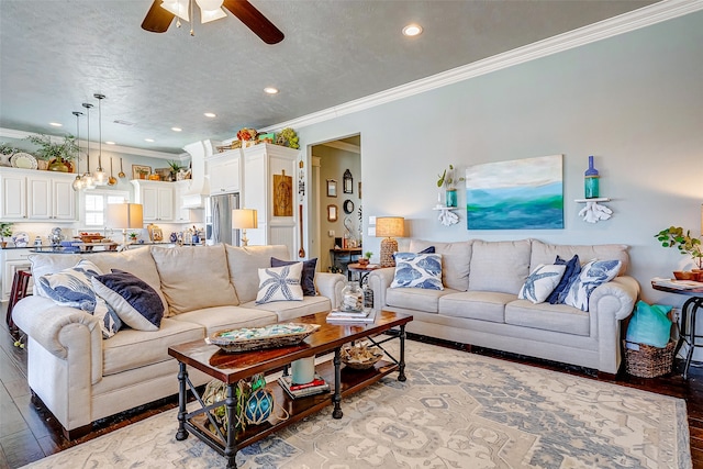 living room with ceiling fan, hardwood / wood-style floors, a textured ceiling, and ornamental molding