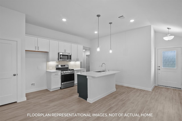 kitchen featuring white cabinets, stainless steel appliances, a kitchen island with sink, and hanging light fixtures