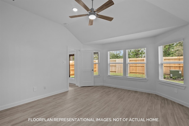 unfurnished room featuring plenty of natural light, ceiling fan, light wood-type flooring, and vaulted ceiling