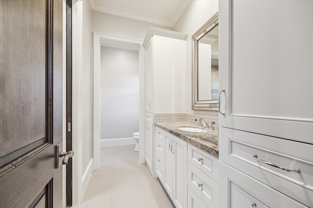 bathroom featuring vanity, tasteful backsplash, toilet, and ornamental molding