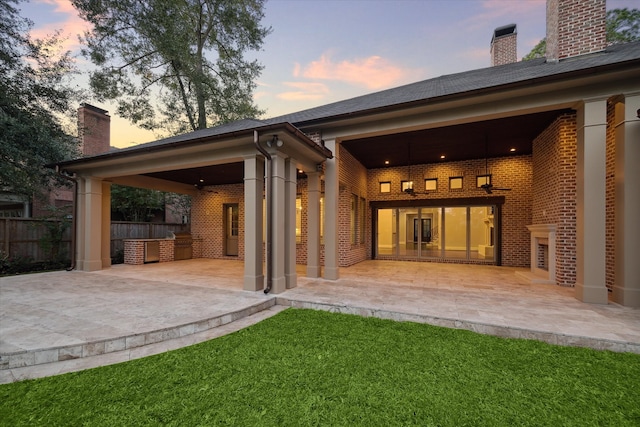 back house at dusk featuring a patio area