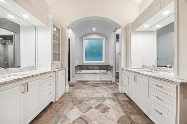 bathroom with plus walk in shower, vanity, and lofted ceiling