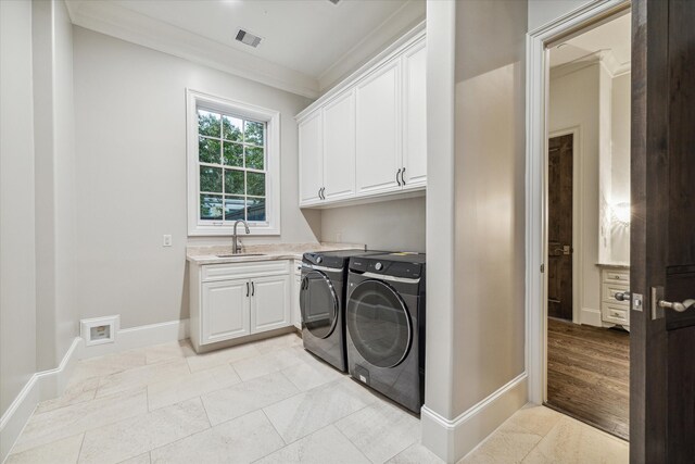 laundry area with cabinets, sink, light hardwood / wood-style flooring, independent washer and dryer, and ornamental molding