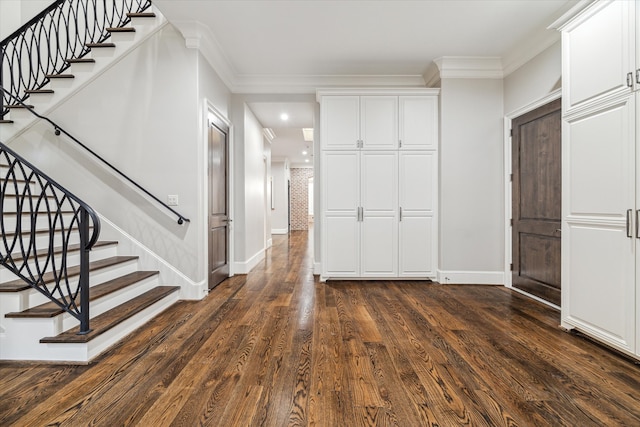 entrance foyer with dark wood-type flooring and ornamental molding