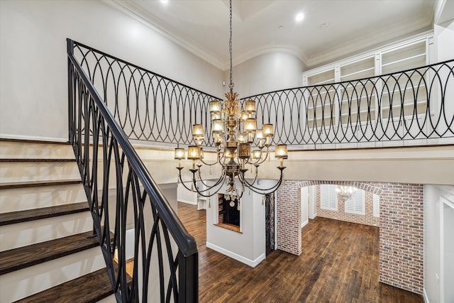 staircase featuring ornamental molding, a chandelier, and hardwood / wood-style flooring