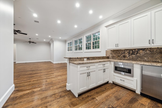 kitchen featuring stainless steel appliances, white cabinetry, dark wood-type flooring, and light stone counters