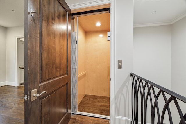 interior details featuring elevator, crown molding, and hardwood / wood-style flooring