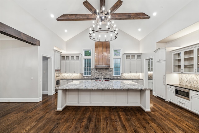 kitchen featuring decorative backsplash, dark wood-type flooring, and a large island