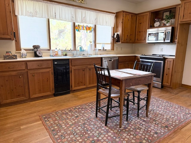 kitchen with stainless steel appliances, light hardwood / wood-style floors, and sink