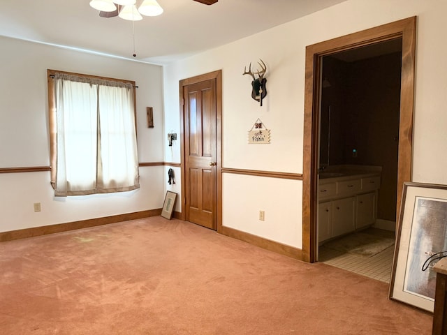 empty room featuring ceiling fan, sink, and light colored carpet