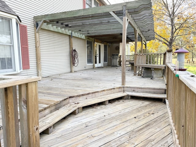 wooden terrace with a pergola and area for grilling