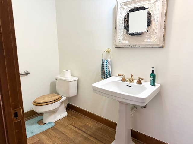 bathroom featuring toilet and wood-type flooring