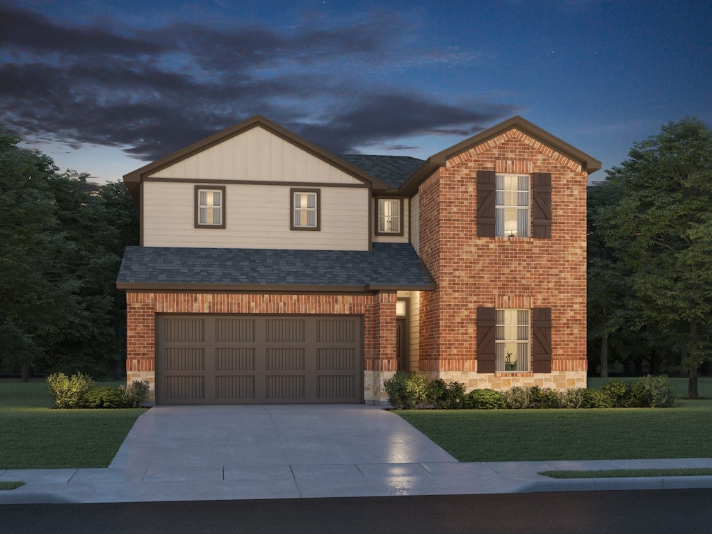 front facade featuring a garage and a yard