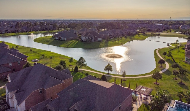 aerial view at dusk featuring a water view