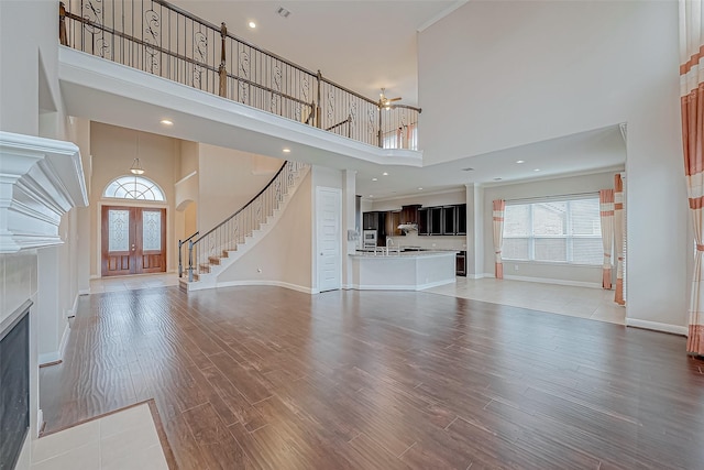 unfurnished living room featuring a high ceiling, french doors, and hardwood / wood-style floors