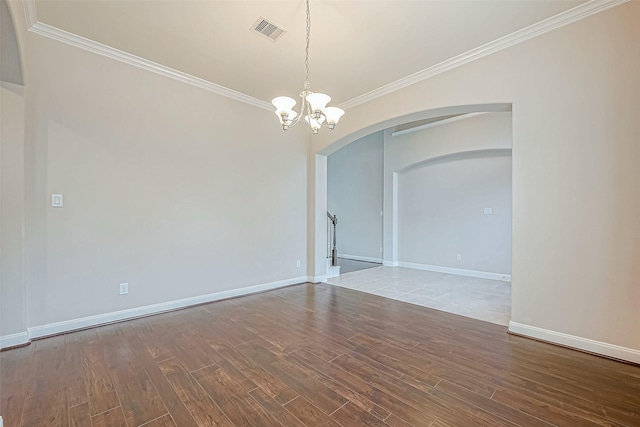 unfurnished room with hardwood / wood-style floors, ornamental molding, and a chandelier