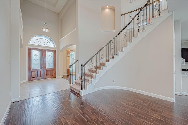 foyer entrance featuring hardwood / wood-style floors, a high ceiling, and french doors