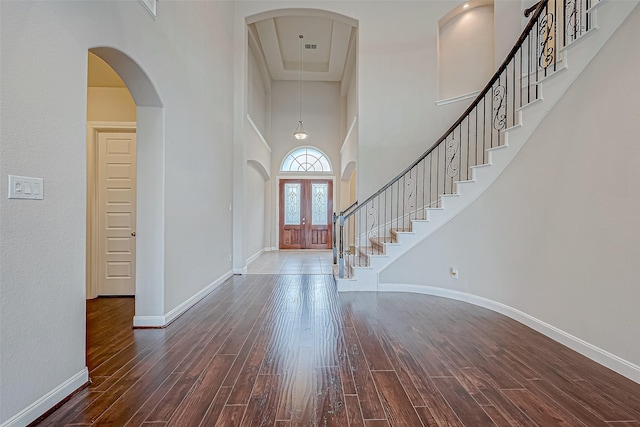 foyer entrance with dark hardwood / wood-style flooring, a high ceiling, and french doors