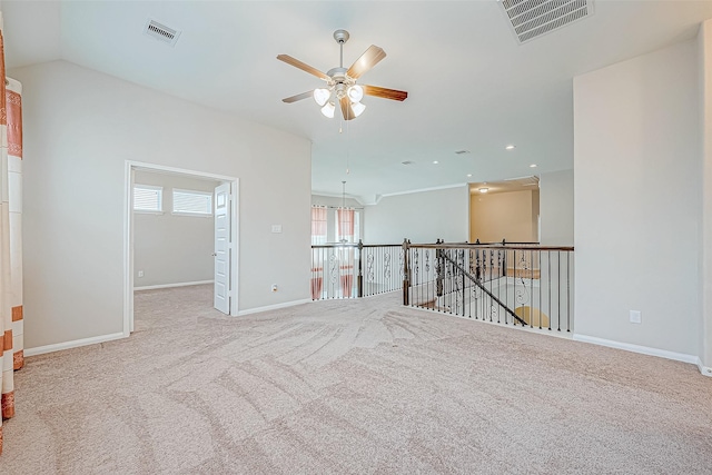 spare room featuring ceiling fan, light colored carpet, and lofted ceiling