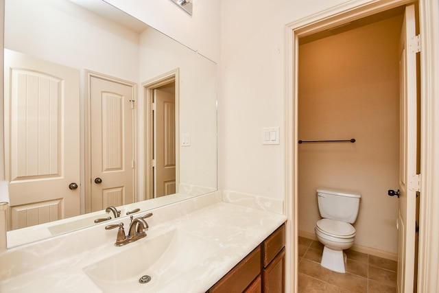 bathroom with tile patterned flooring, vanity, and toilet