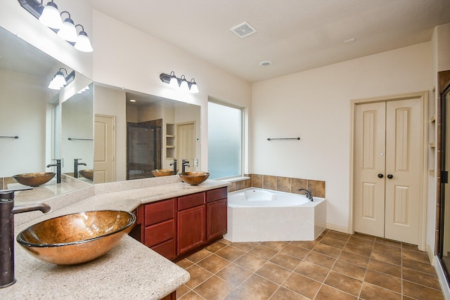 bathroom with tile patterned floors, vanity, and separate shower and tub