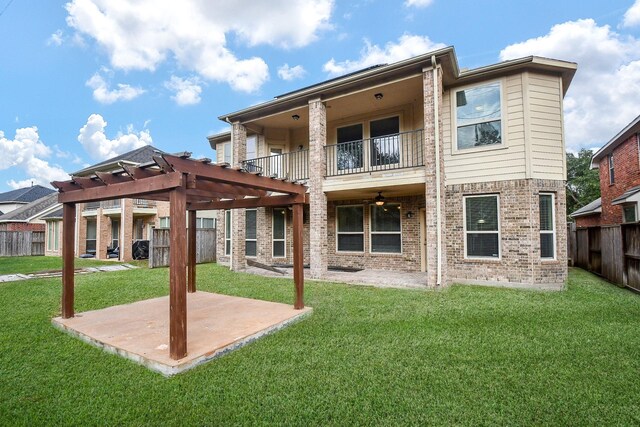 back of property featuring a pergola, a balcony, a lawn, and a patio