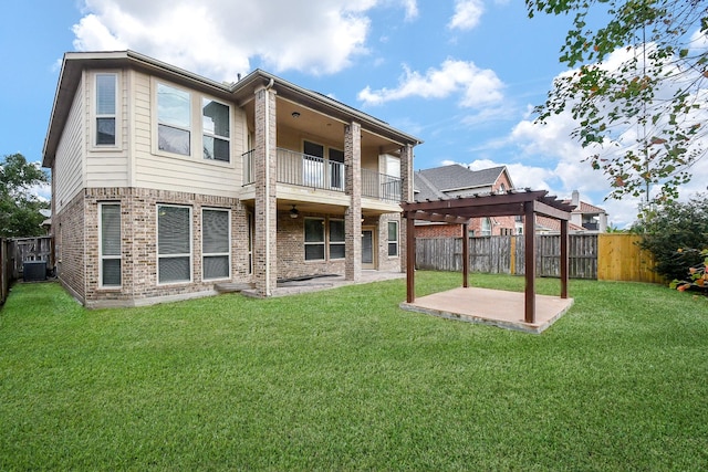 rear view of property with a pergola, a balcony, central AC unit, a patio area, and a lawn