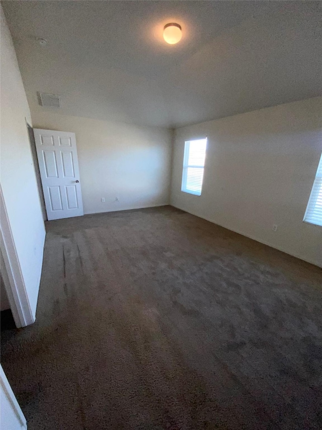 carpeted empty room with a textured ceiling