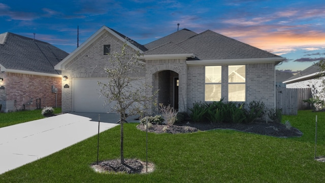 view of front of house featuring a garage and a lawn