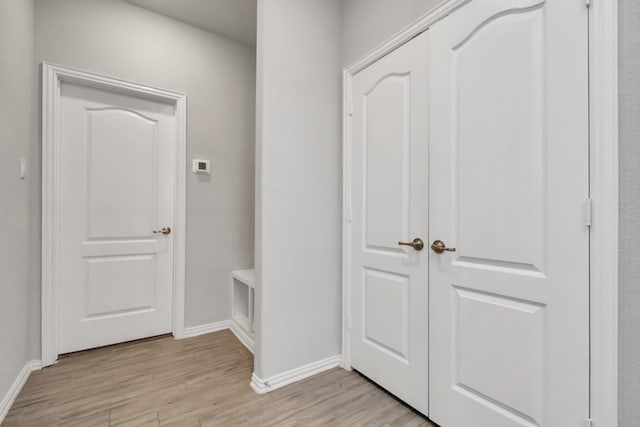 corridor with light hardwood / wood-style floors