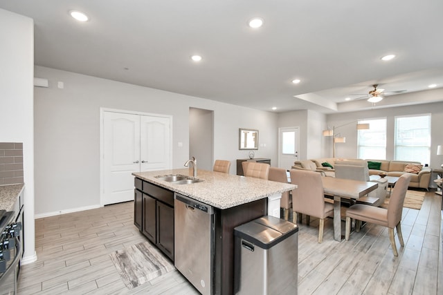 kitchen featuring stainless steel appliances, light hardwood / wood-style flooring, a kitchen island with sink, and sink