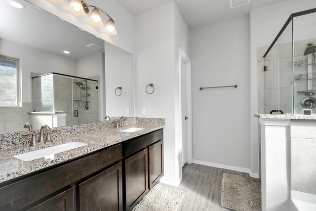 bathroom featuring vanity, hardwood / wood-style flooring, and a shower with shower door