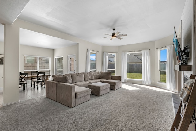 living room featuring ceiling fan, a healthy amount of sunlight, and light carpet