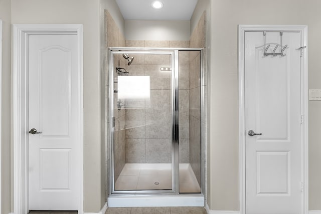 bathroom featuring tile patterned floors and a shower with door