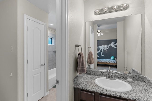 bathroom with tile patterned flooring, vanity, ceiling fan, and a washtub