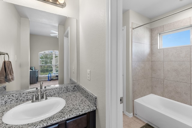 bathroom featuring tile patterned flooring, vanity, and tiled shower / bath