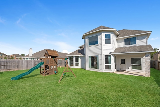 back of property featuring a playground and a lawn