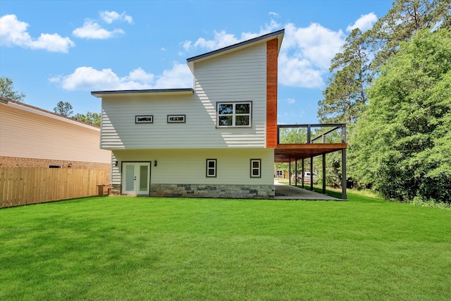 rear view of property with a lawn, a patio, and a deck