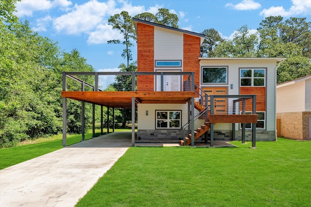 back of property with a carport, a wooden deck, and a lawn