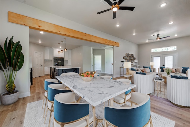 dining area featuring ceiling fan, french doors, sink, and light hardwood / wood-style flooring