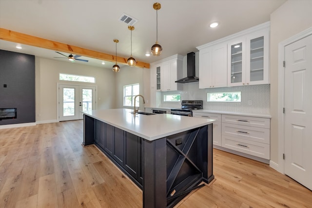 kitchen featuring white cabinets, electric range, sink, and wall chimney exhaust hood