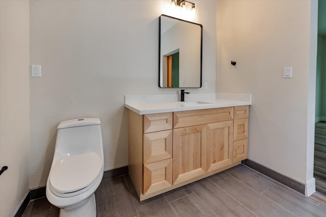 bathroom featuring toilet, vanity, and hardwood / wood-style flooring